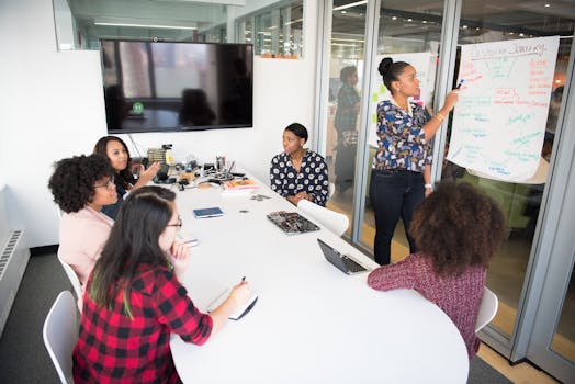 A multicultural office team engages in a collaborative brainstorming session around a conference table.